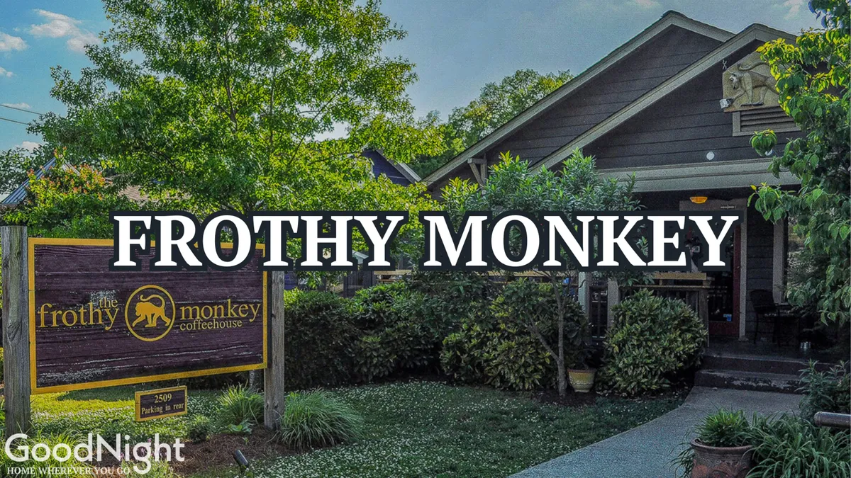 The friendly entrance of Frothy Monkey coffeehouse, framed by lush greenery. Warm and inviting, the facade hints at the lively local café culture, ideal for business travelers seeking coffee breaks or casual meetings.